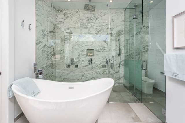Marble bathroom with a freestanding tub and glass shower