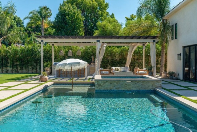 Pool with pavers and lounge area in a large backyard