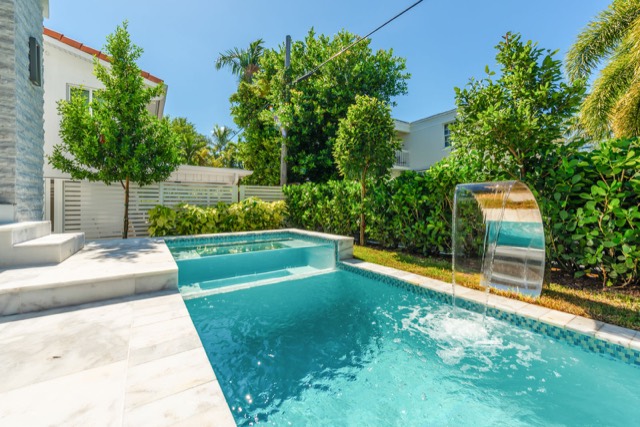 Long rectangular pool in a landscaped backyard