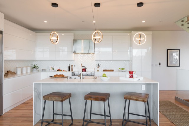 White kitchen with a waterfall island and bar stools