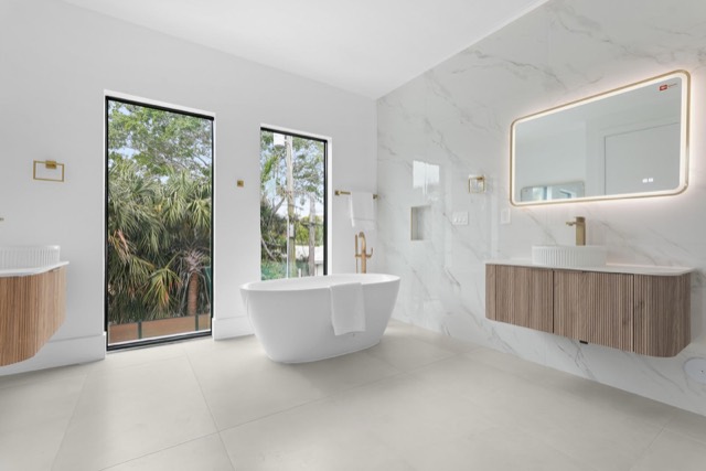 Bright primary bathroom with a freestanding tub and wood vanity