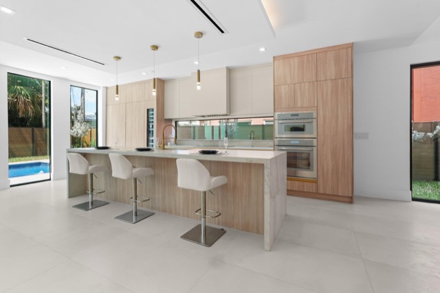 Kitchen with a long island opening to the backyard
