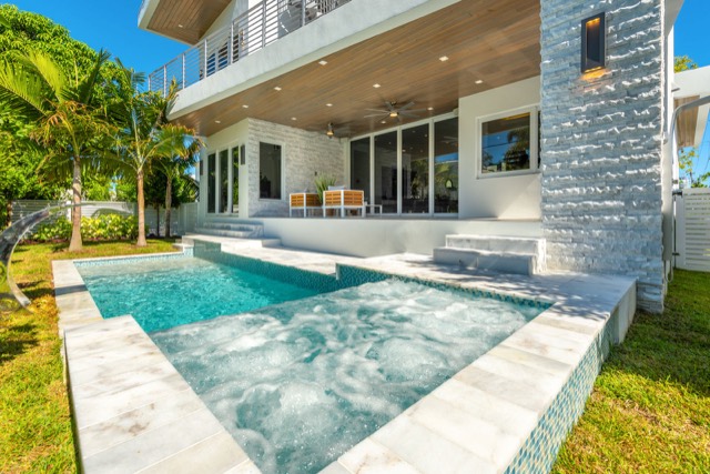 Swimming pool with a raised spa beside a modern two-story home