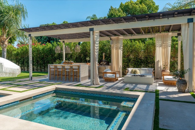 Pool with paver deck and a pergola-covered seating area
